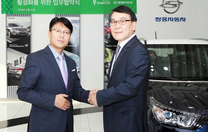 이광섭 쌍용차 상무(오른쪽)와 이용호 그린카 사장이 협력관계를 다짐하며 악수를 나누는 모습.