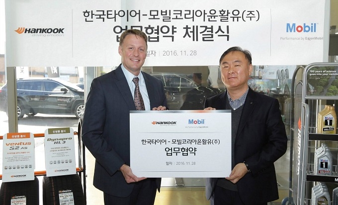 사이먼 리즈 모빌코리아윤활유 사장과 이태환 한국타이어 리테일부문 상무가 업무협약을 마치고 포즈를 취한 모습.