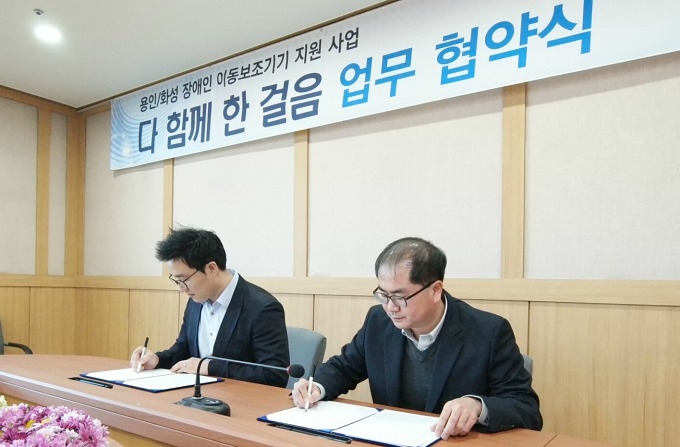 삼성전자 기흥-화성캠퍼스 노사협의회 이명훈 사원 대표와 강인학 경기도재활공학서비스연구지원센터장이 협약서에 서명하는 모습.