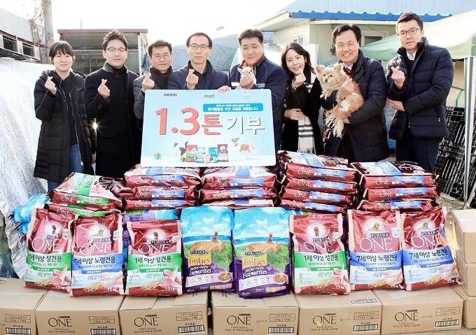 네슬레 퓨리나와 이마트 임직원들이 유기동물 보호소에 사료를 전달하고 포즈를 취한 모습.